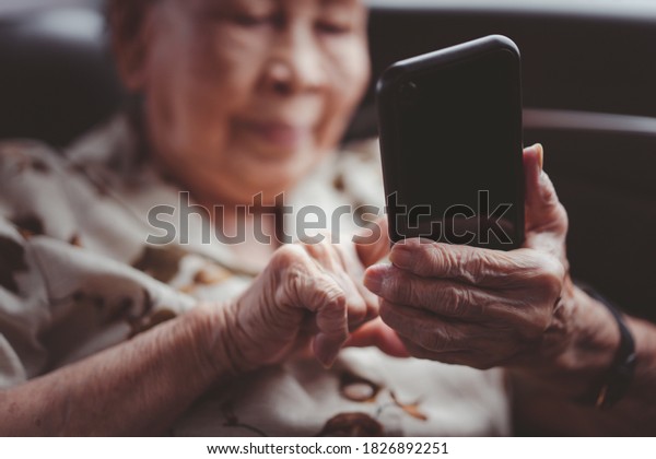 Very old
Asian passenger woman age between 80 - 90 years old traveling by
the car while raining and using a video call. Cheerful retired
woman in a private car portrait with copy
space.