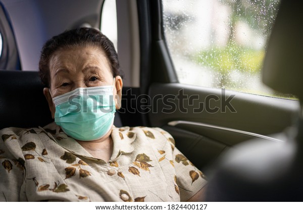 Very old Asian woman age between 80 -90 years\
old travel by the personal car, elder woman using protective face\
mask during traveling. Coronavirus or COVID-19 pandemic concept.\
COVID19 outbreak.