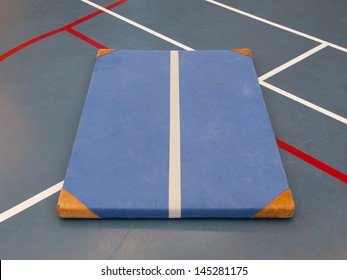 Very old blue mat on a blue court, school gym