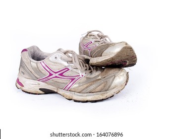 Very Old Dirty Pair Of Running Shoes Over A White Background