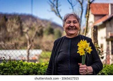 Very Old Happy Woman Laughing And Holding Flowers