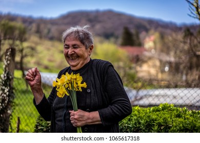 Very Old Happy Woman Laughing And Holding Flowers