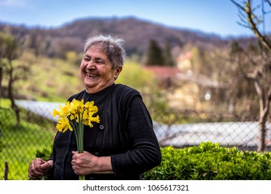 Very Old Happy Woman Laughing And Holding Flowers