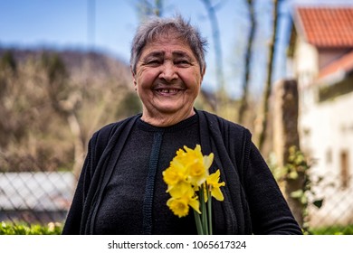 Very Old Happy Woman Laughing And Holding Flowers