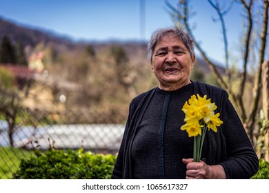 Very Old Happy Woman Laughing And Holding Flowers