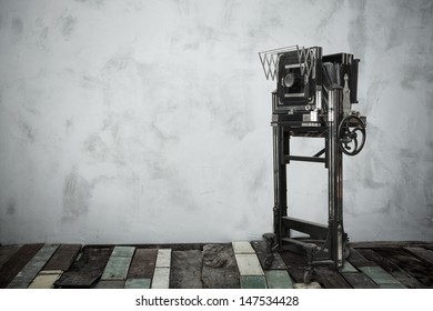 very old large format camera in room with wooden floor and vignette