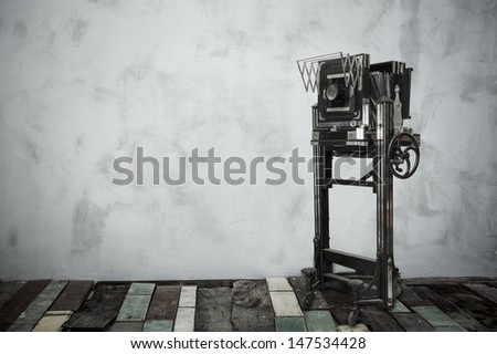 very old large format camera in room with wooden floor and vignette