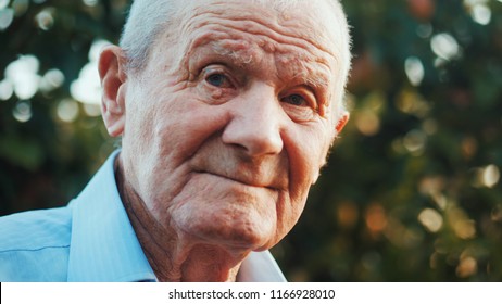 Very Old Man Boomer Portrait With Emotions. Grandfather Is Smiling And Looking To Camera. Portrait: Aged, Elderly, Senior. Close-up Of Old Man Sitting Alone Outdoors.