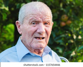 Very Old Man Portrait. Grandfather Is Smiling And Looking To Camera. Portrait: Aged, Elderly, Senior. Close-up Of Old Man Sitting Alone Outdoors.