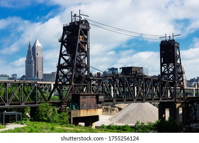 A very old railroad drawbridge spanning the Cuyahoga River with part of the downtown Cleveland, Ohio skyline in the background