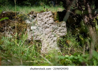 Very Old Single Tombstone Made Of Red Sandstone Overgrown With Grass And Weeds