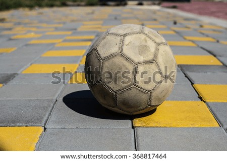 Very old soccer ball on the ground near football stadium