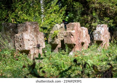 Very Old Tombstones Made Of Red Sandstone Overgrown With Grass And Weeds