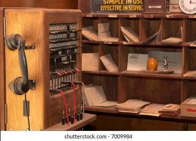 A Very Old Wall Telephone In Front Of Mail Sorting Boxes