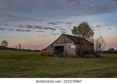 A Very Old, Weathered And Rustic Barn In A Farm Field On A Autumn Morning.  Agriculture.  Building. Barn. Vintage. Rustic. Landscape. Morning.  Sunrise. Dramatic Sky