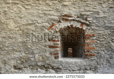 Very old window in brick stone wall of castle or fortress of 18th century. Full frame wall with window close up