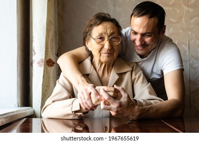 a very old woman and an adult grandson