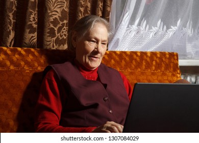 Very Old Woman Using Laptop Sitting In Her Sofa