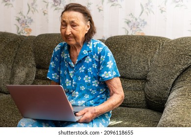 Very Old Woman Using Laptop Sitting In Her Sofa