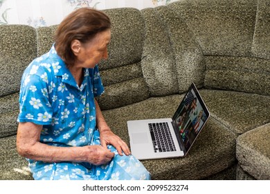 Very Old Woman Using Laptop Sitting In Her Sofa