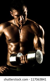 very power athletic guy ,  execute exercise with  dumbbells, on bkack background