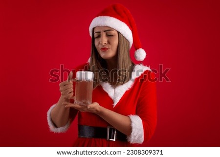 Very pretty adult woman holding a glass of beer, wearing a Santa Claus hat and dress, in a studio shot with a red background, with space for text, and making various facial expressions