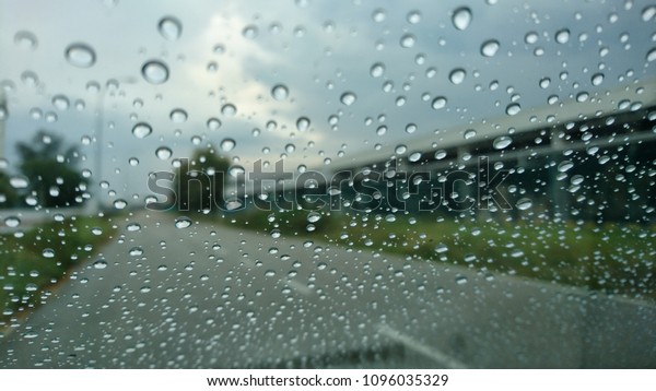 A very
rare rainy day with car and people as seen through car windows with
rain drops visible on the window. Blured background with rains drop
on glass and cars on the road.- soft
focus