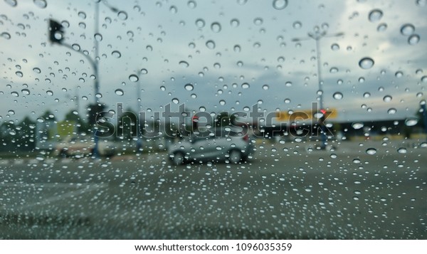 A very
rare rainy day with car and people as seen through car windows with
rain drops visible on the window. Blured background with rains drop
on glass and cars on the road.- soft
focus