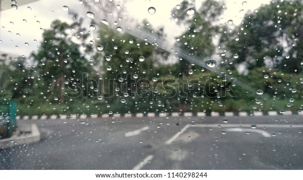 A very\
rare rainy day with car and people as seen through car windows with\
rain drops visible on the window. Blured background with rains drop\
on glass and cars on the road.- soft\
focus