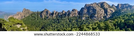 Very rocky Corsican mountain range of the Aiguilles de Bavella in summer, very tall and wide massif of France, near Zonza in Conca forest, with some trees in bottom Imagine de stoc © 