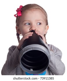 A Very Serious Young Child Is Talking Secretly Into Her Pretend Microphone.  She Is Keeping An Eye On Someone So They Do Not See Her.