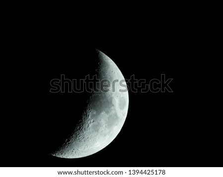 a very sharp close-up of the rising crescent moon in the night sky