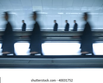 Very Similar People Walking On The Same Direction Through A Shiny Tunnel. Blurred Motion.