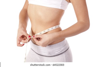 A very skinny woman is measuring her waist.