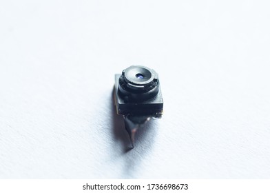 Very small camera with a torn loop close up on a white background.
