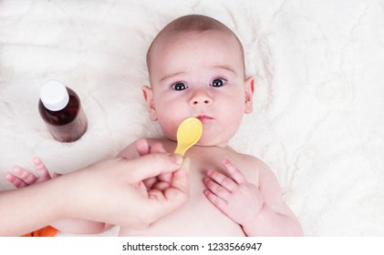 A Very Small Child, A Baby At The Doctor's Office And He Is Given A Medicine For Coughing And Allergies From A Spoon.