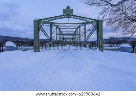 A very snowy view of the historic and restored South Washington Street Bridge in Binghamton, New York. The Lenticular through truss carries a bicycle and walking path over the Susquehanna River.