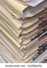 A Very Tall Stack Of Paper Patient Records From A Medical Clinic Or Office In A Vertical Image Format.