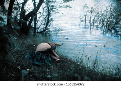 Very Thin Girl Sits On The Lake With A Bare Back