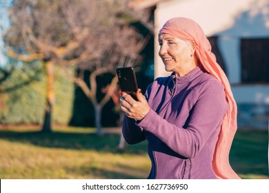 Very Thin Older Woman With Headscarf And Mobile Phone In Hand, Concept Of Cancer Patient