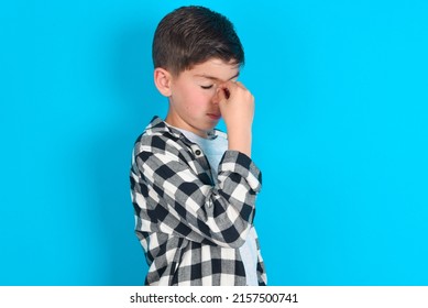 Very Upset, Caucasian Kid Boy Wearing Plaid Shirt Over Blue Background Touching Nose Between Closed Eyes, Wants To Cry, Having Stressful Relationship Or Having Troubles With Work