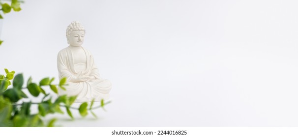 Vesak Day is holy day for Buddhists. Happy Buddha Day with Siddhartha Gautama statue on white background. Mental health and meditation concept. Selective soft focus.