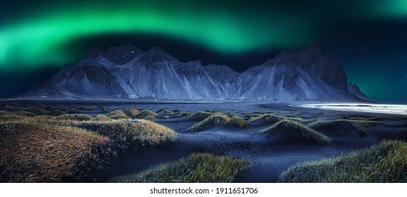 Vestrahorn mountaine on Stokksnes cape in Iceland with Green northern lights. Amazing Iceland nature seascape. popular tourist attraction. Best famouse travel locations. Scenic Image of Iceland