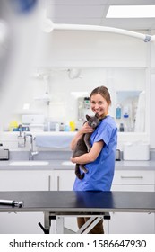 Vet Nurse Holding Pet Cat By Table In Vet Surgery Smiling At Camera