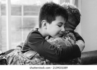 Veteran father hugging his kid son after homecoming reunion - Family love and war concept - Focus on child face - Black and white editing