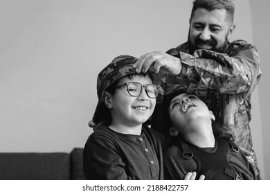 Veteran soldier greeting his sons reunited after US army service - Diverse family concept - Black and white editing - Powered by Shutterstock