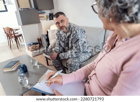Veteran soldier having therapy meeting with senior female psychologist.