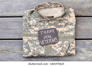 Veteran's Camo Jacket, Top View. Thank You Veterans, Wooden Background.