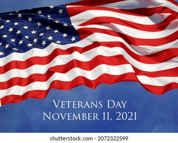 Veterans Day 2021 concept. USA flag with November 11, 2021 flying against a bright blue sky.