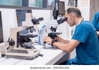 Veterinarian examining samples under a microscope in a lab